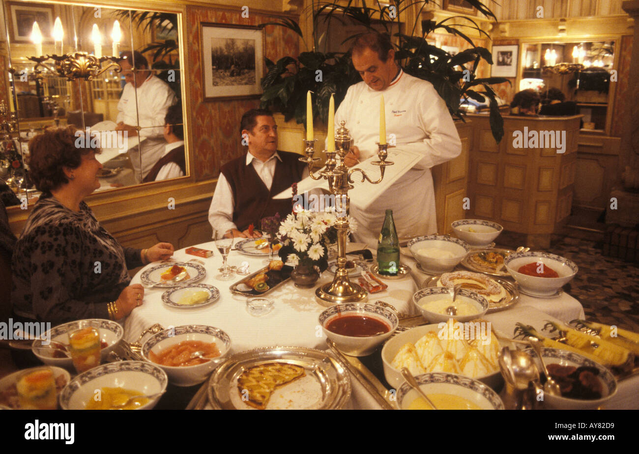 Paul Bocuse französischer Koch Lyon France. Er signiert Menüs in seinem Restaurant für ein Paar, das ihr Mittagessen essen will. 1980er Jahre 1985 HOMER SYKES Stockfoto