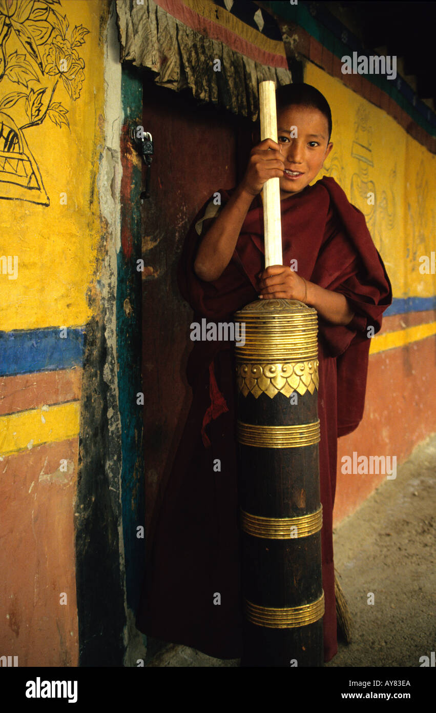 Junger Mönch Buttern Yak Buttertee in traditionelle hölzerne Urne im Kloster in Tibet Stockfoto