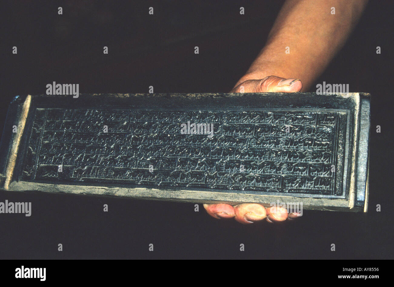 Mönch s Hand mit traditionellen Druck Holzblock für buddhistische Schriften und Bücher Stockfoto