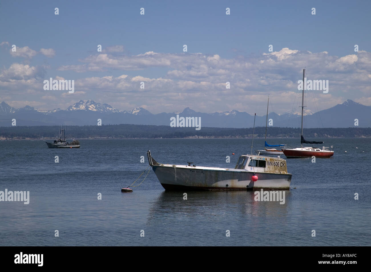 Boote in der Nähe von Marina auf der Saratoga Passage Langley Whidbey Island Washington mit North Cascade Mountains in Ferne Stockfoto