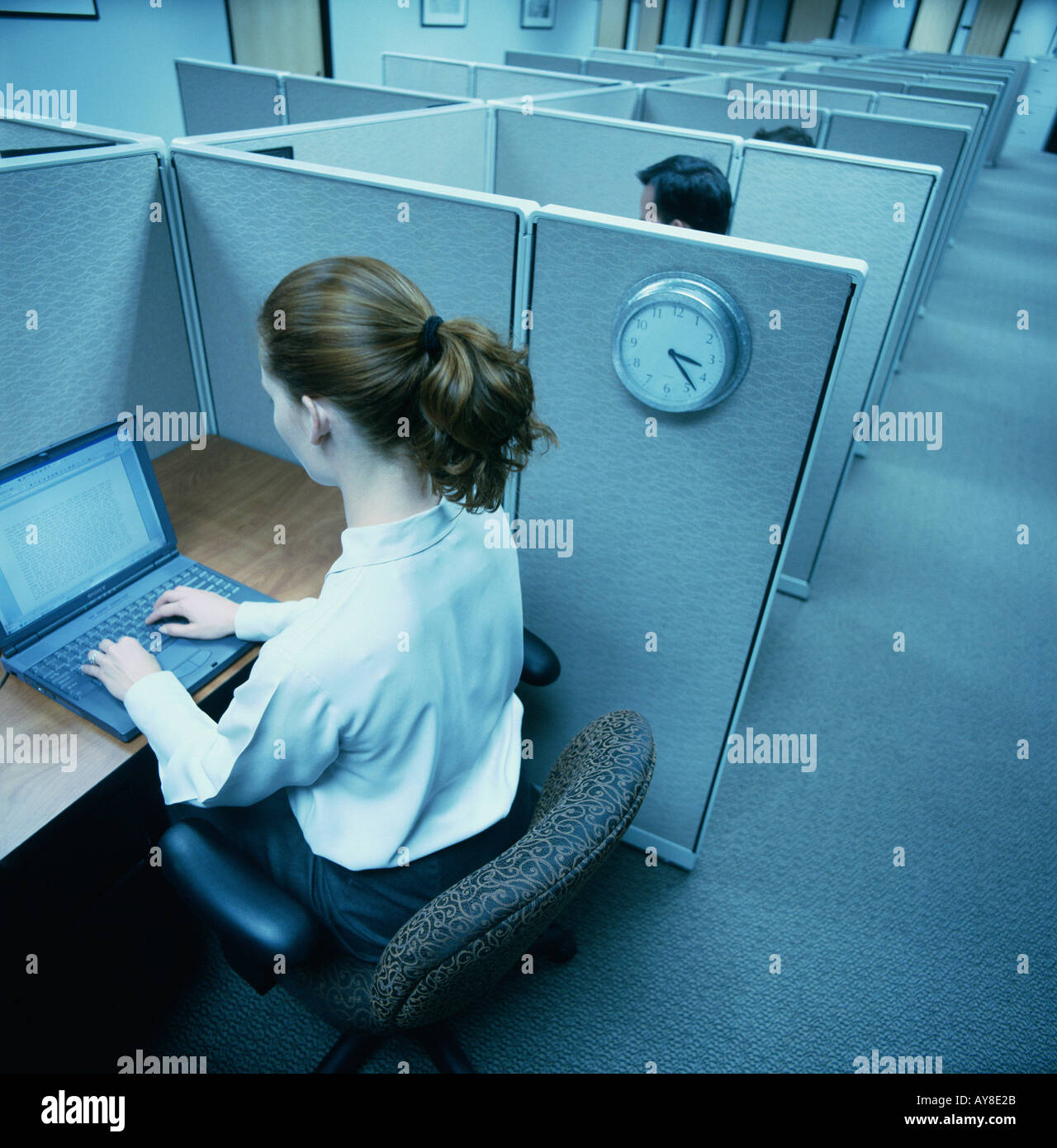 Arbeitnehmerin arbeitet auf tragbaren Computer in kleinen Großraumbüro Stockfoto