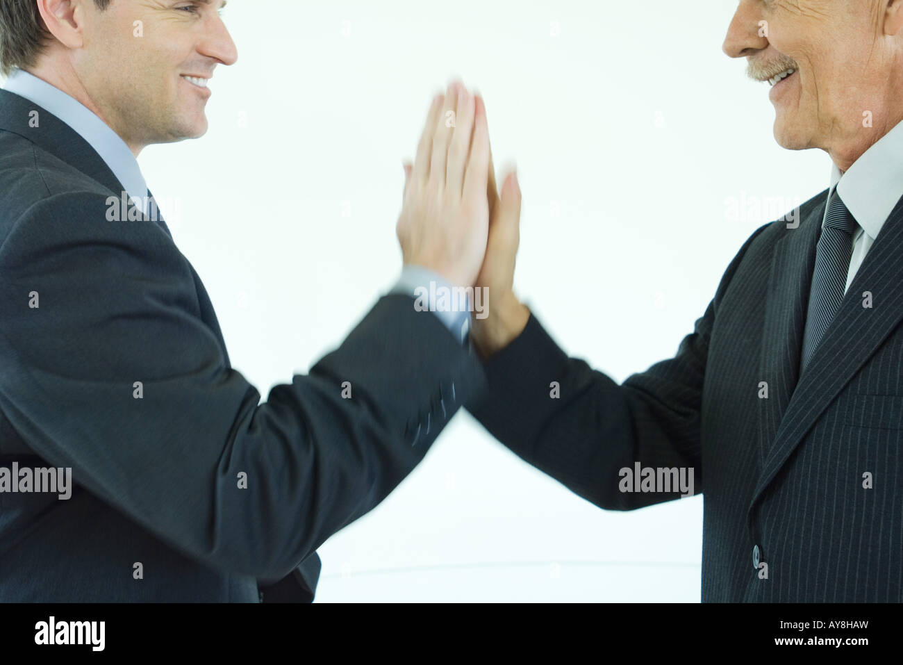 Zwei Geschäftsleute geben einander ein High-Five, beschnittenen Seitenansicht Stockfoto