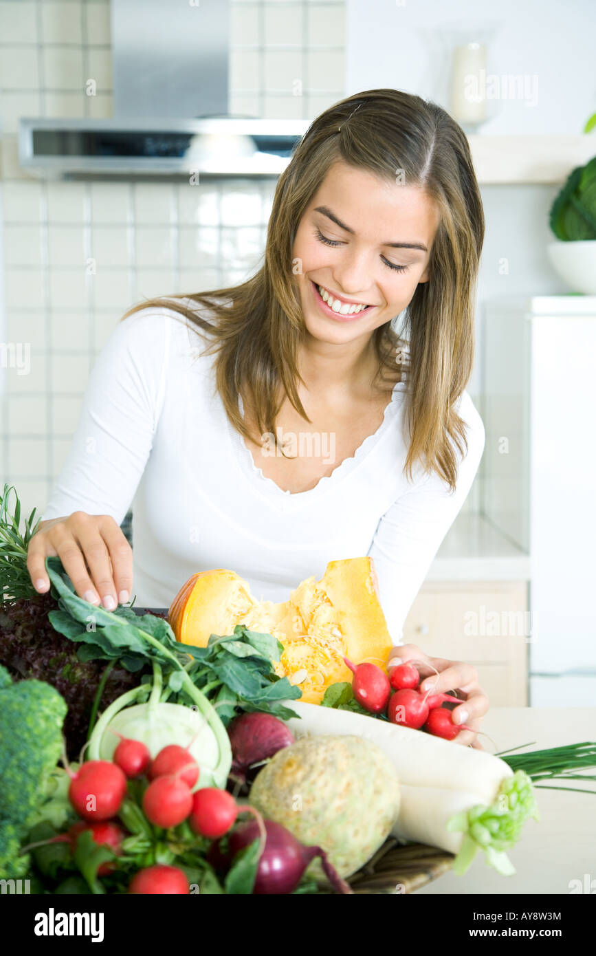 Junge Frau in Küche, frisches Gemüse, lächelnd sortiert blickte auf Stockfoto