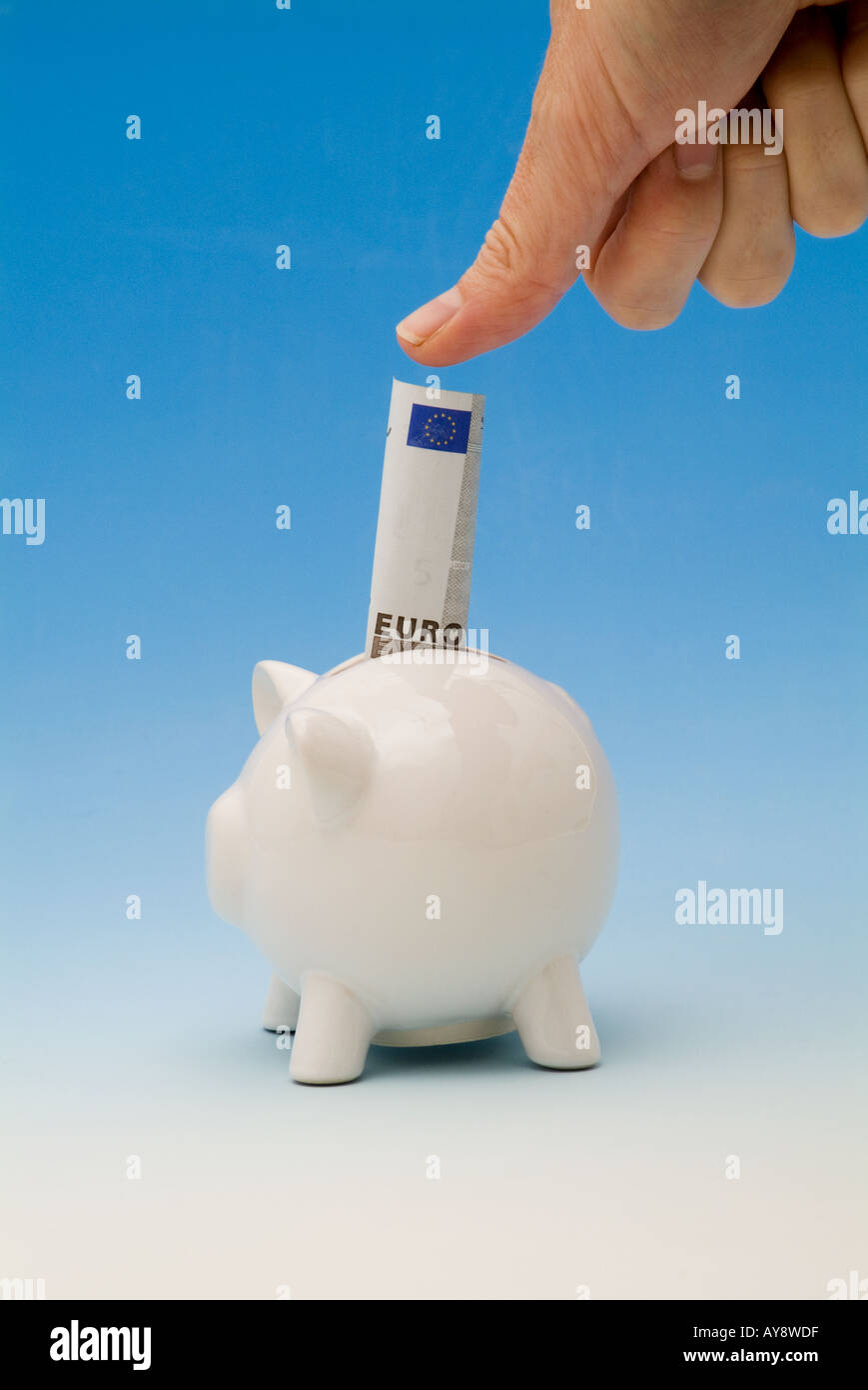 Daumen drücken ein-Euro-Schein in ein Sparschwein Stockfoto