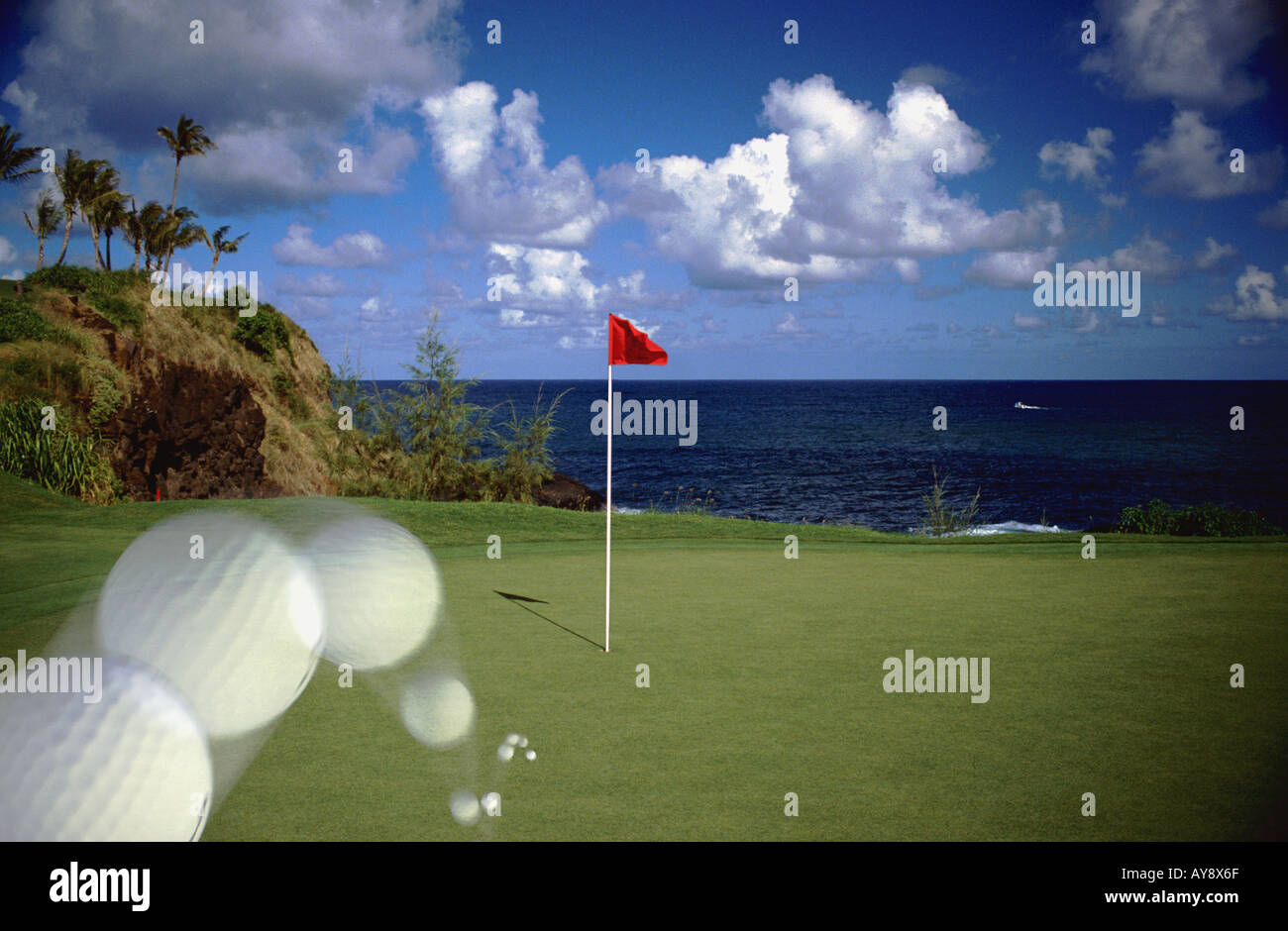 Golf-Bäume Wasser Ozean Kurs in Kauai Lagunen - Kiele Golfplatz Hawaii Kugel in Bewegung Landung auf grün, Loch in einem, Stockfoto