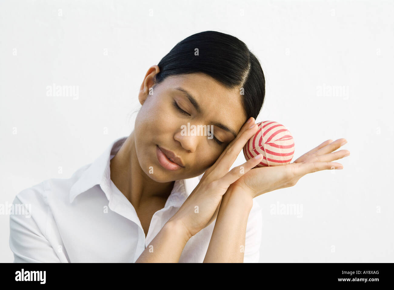 Junge Frau Kopf auf die Hände, halten Ball, Augen geschlossen Stockfoto