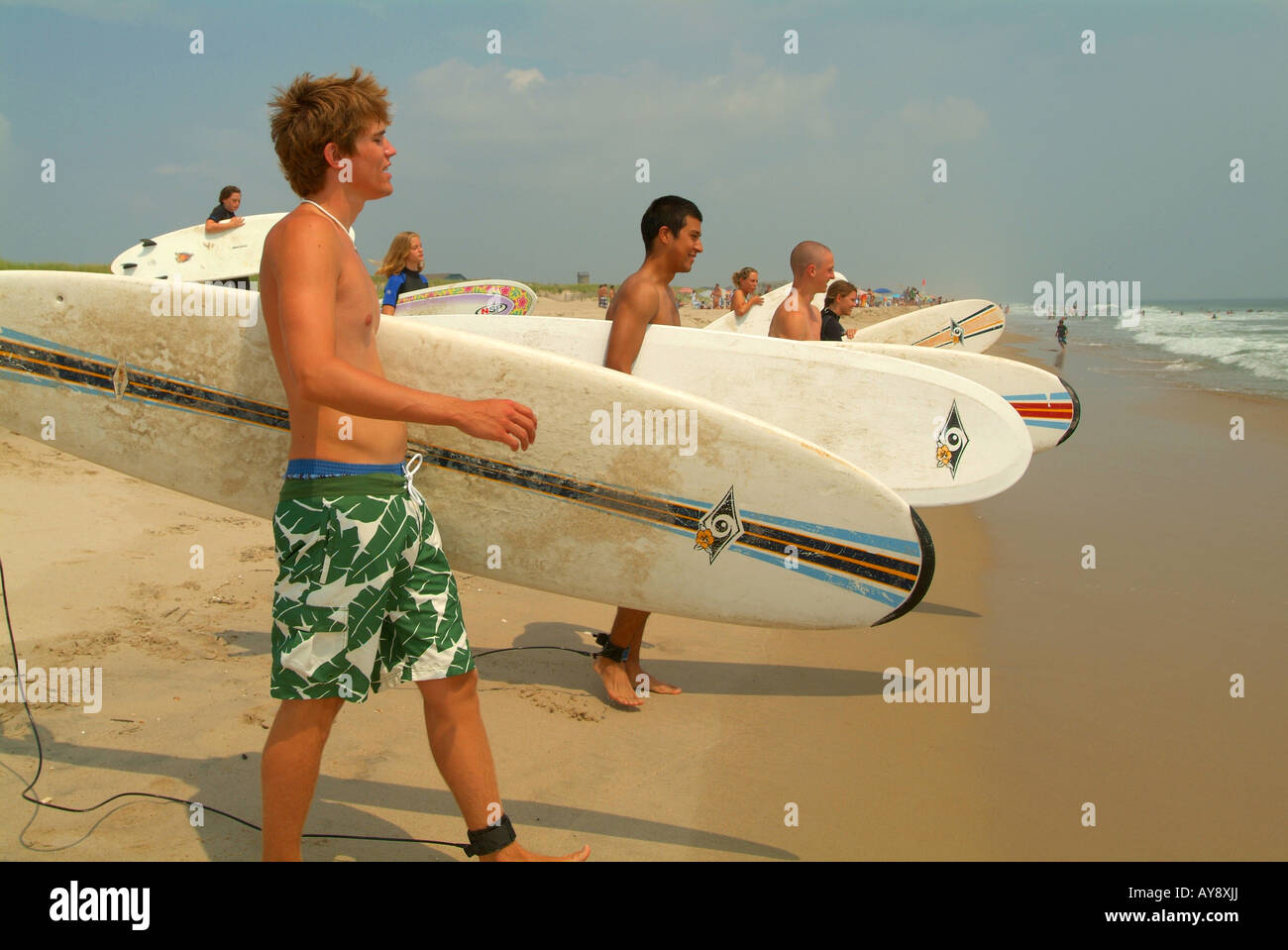 Die jungen Studenten erhalten eine schnelle Lektion am Strand vor der Überschrift in der Brandung Stockfoto