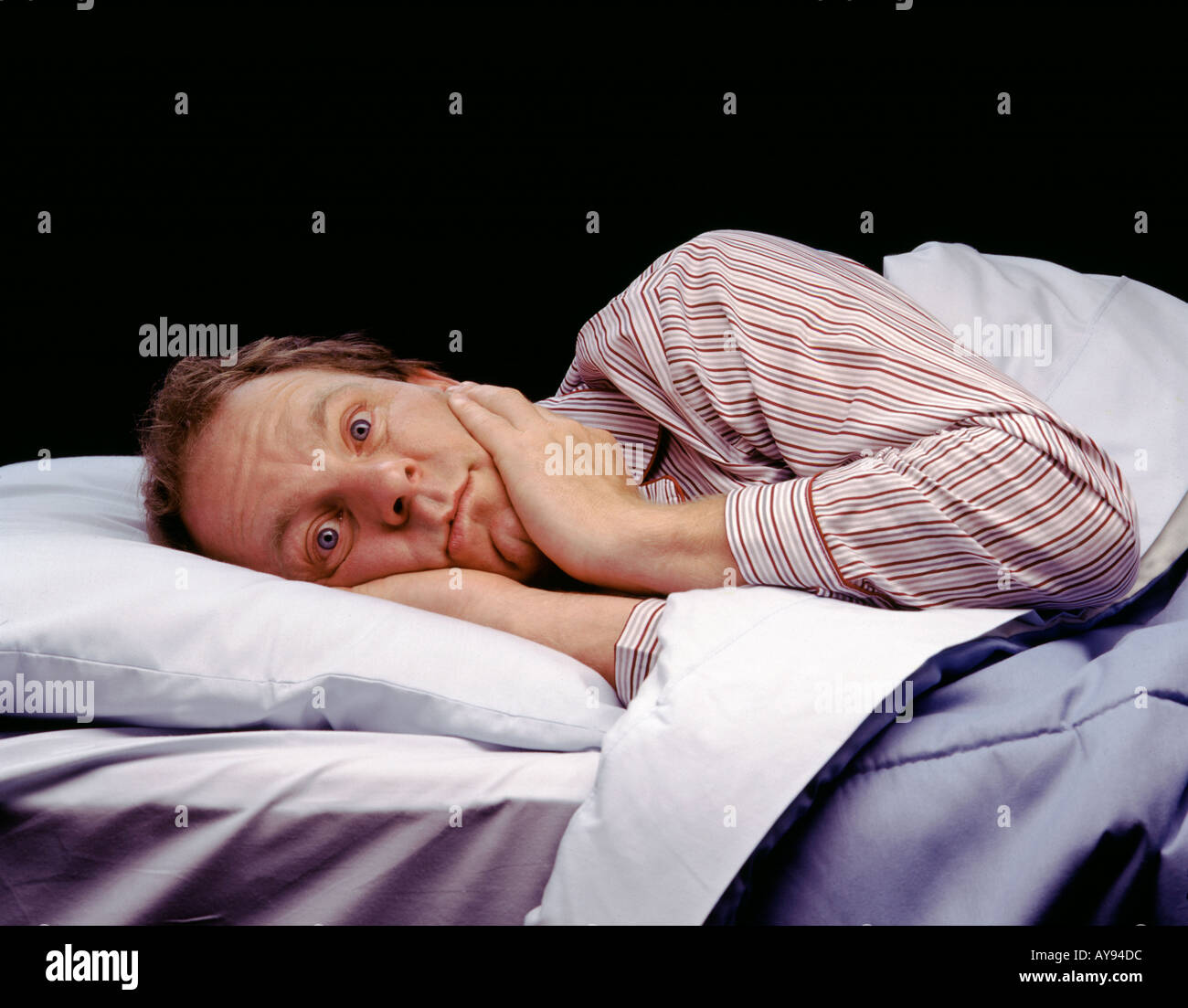 Mann wach im Bett nicht schlafen Stockfoto