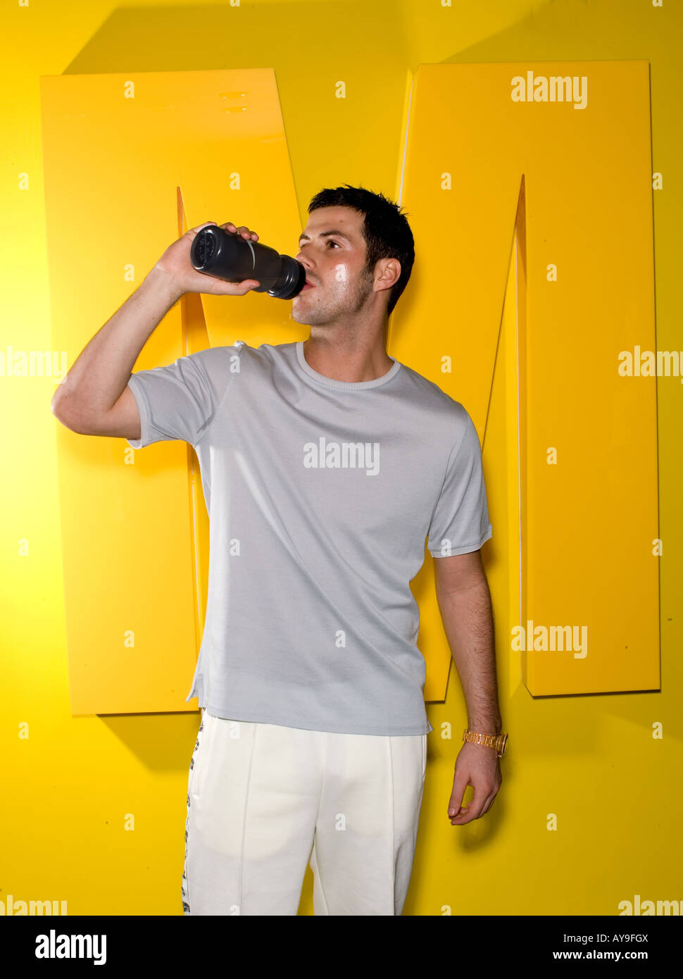 Mann trinkt aus Flasche Wasser und Buchstabe M Stockfoto