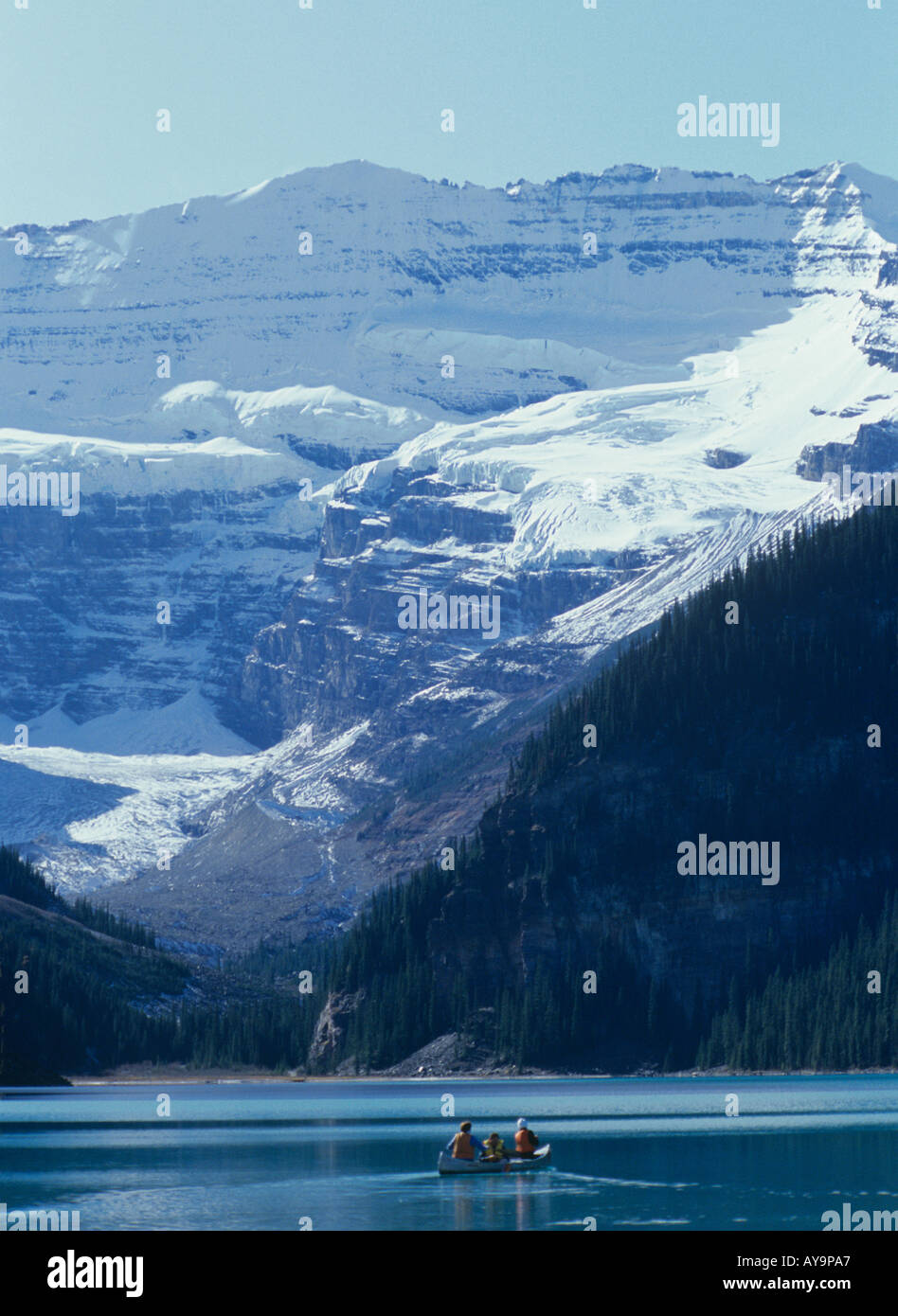 Besucher nach Lake Louise im Banff Nationalpark paddeln Kanu unter Schnee bedeckt Gipfeln Alberta Kanada Stockfoto