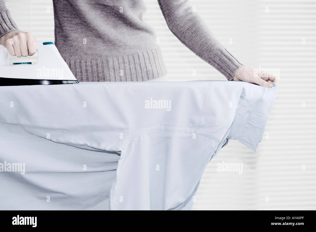 Eine junge Frau Bügeln Shirt Stockfoto