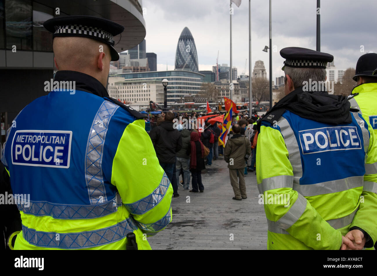 Vor Menschenmassen auf Anzeichen von heftigen Protest während des Olympischen Fackellaufs, London Metropolitanpolizei. China-Fahnen und Gurke Stockfoto
