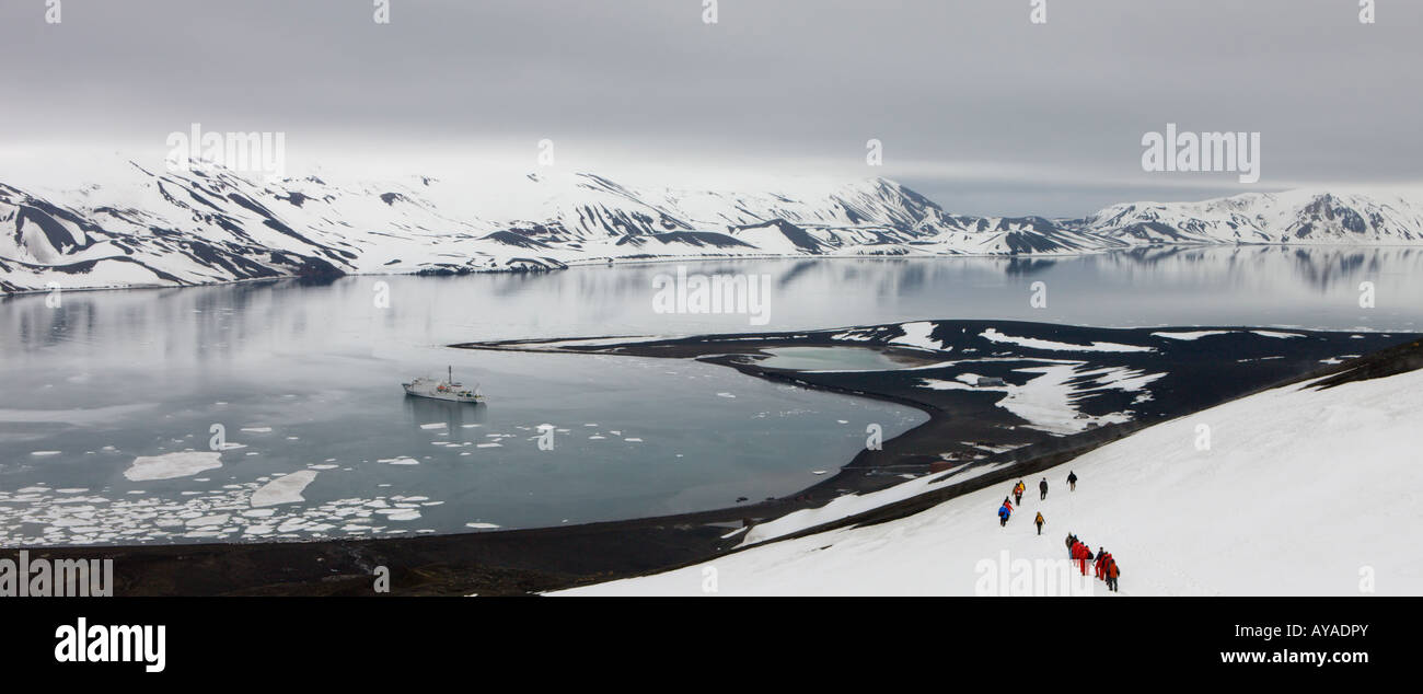 Touristen, die den Berg in Richtung Whalers Bay, Deception Island, Antarktis hinunter wandern Stockfoto