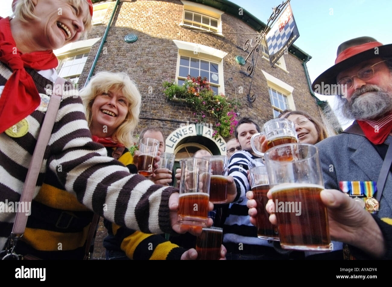 Eine Schar von Stammgästen in einem traditionellen Pub Sussex heben das Glas von ihren Lieblings-Gebräu. Stockfoto