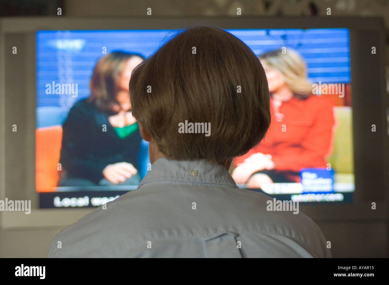 Hausfrau beobachten Seifenoper auf einen neuen LCD-Fernseher Stockfoto