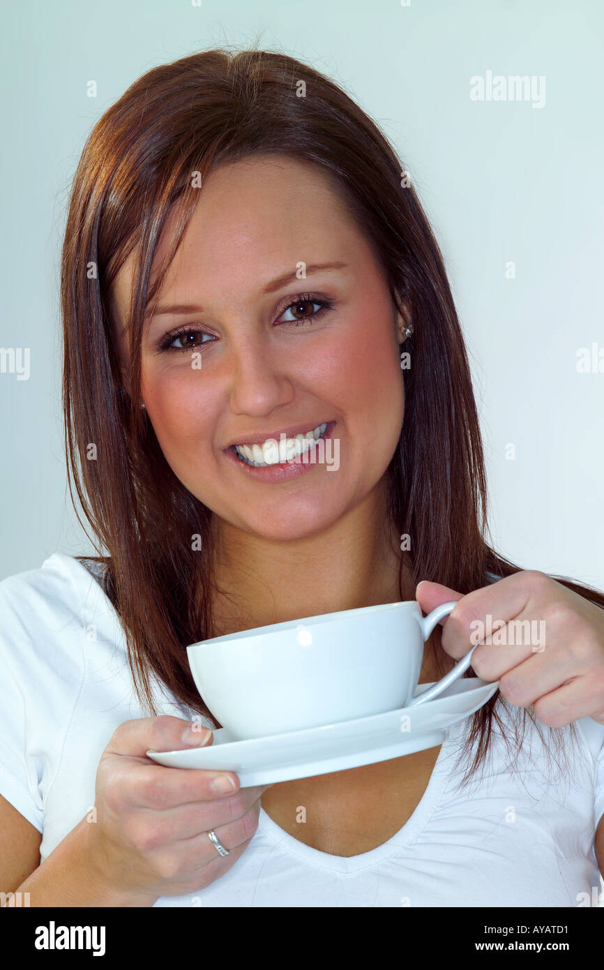 Porträt der jungen Frau hält Teetasse und Untertasse Stockfoto
