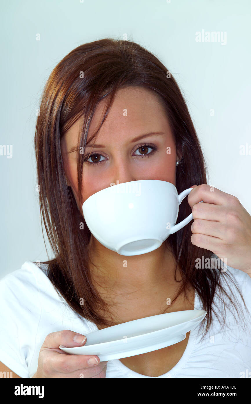 Porträt der jungen Frau Trinken von Teetasse und Untertasse Stockfoto