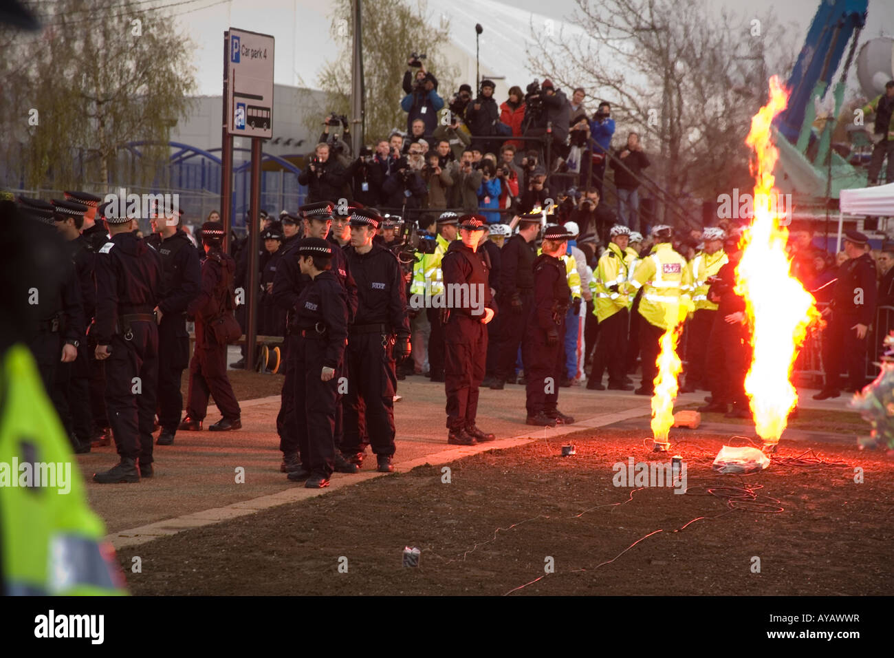 Feuerwerk am Ende der Olympischen Fackel Prozession durch London. Die Fackel wird von einer großen Gruppe von Polizei bewacht wird. Stockfoto