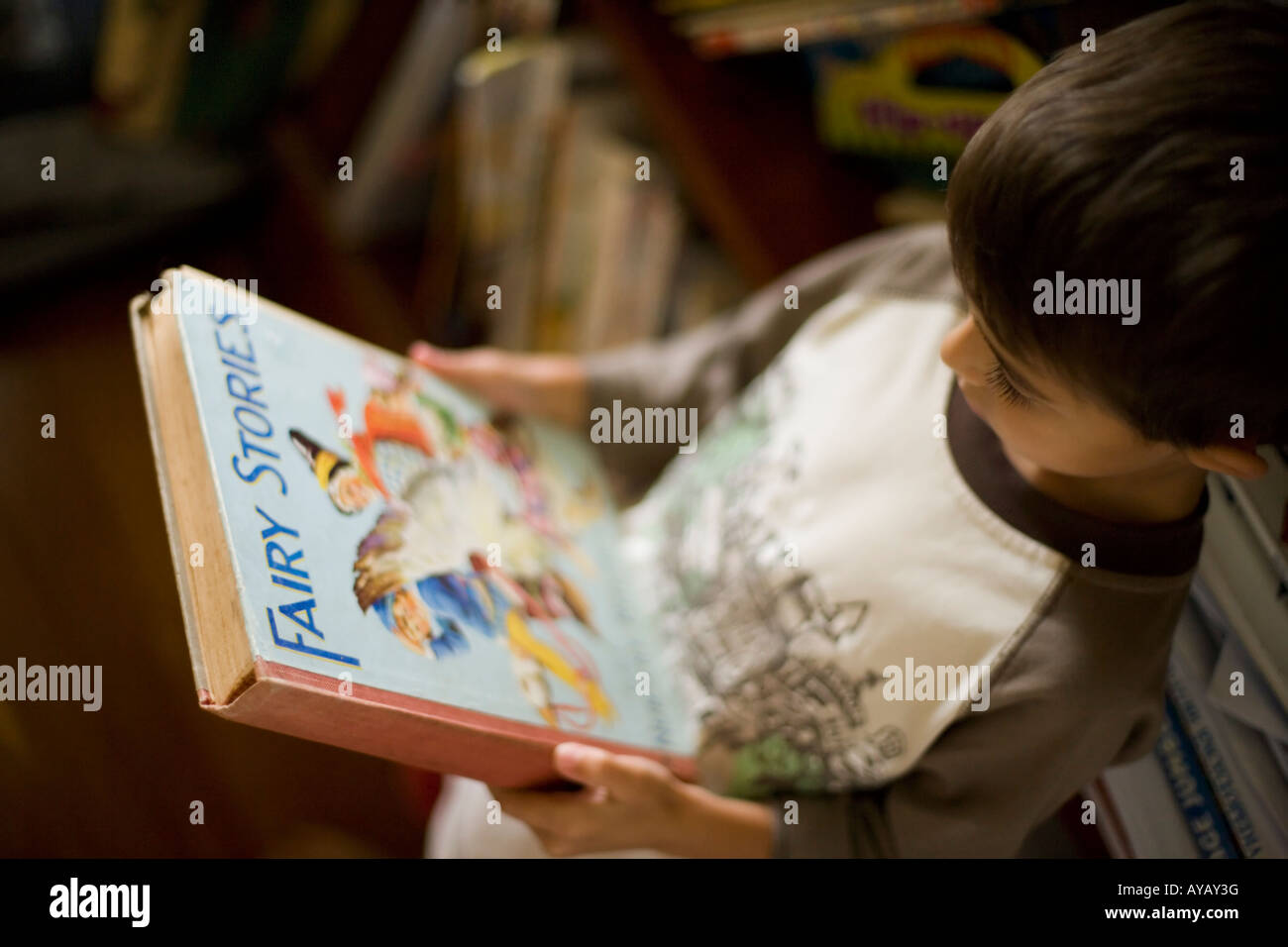 Jungen im Alter von sechs Jahren liest Buch der Märchen und Kinderlieder. Stockfoto