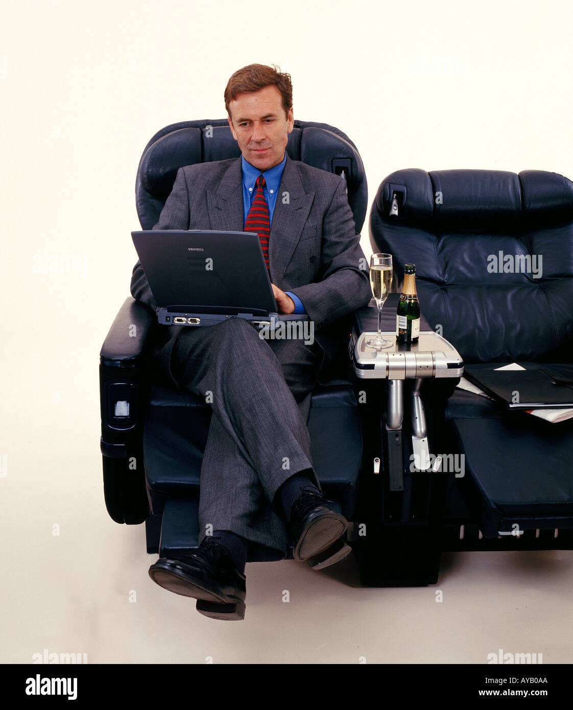 Führungskraft mit Laptop-Computer sitzen in der ersten Klasse reisen Stockfoto