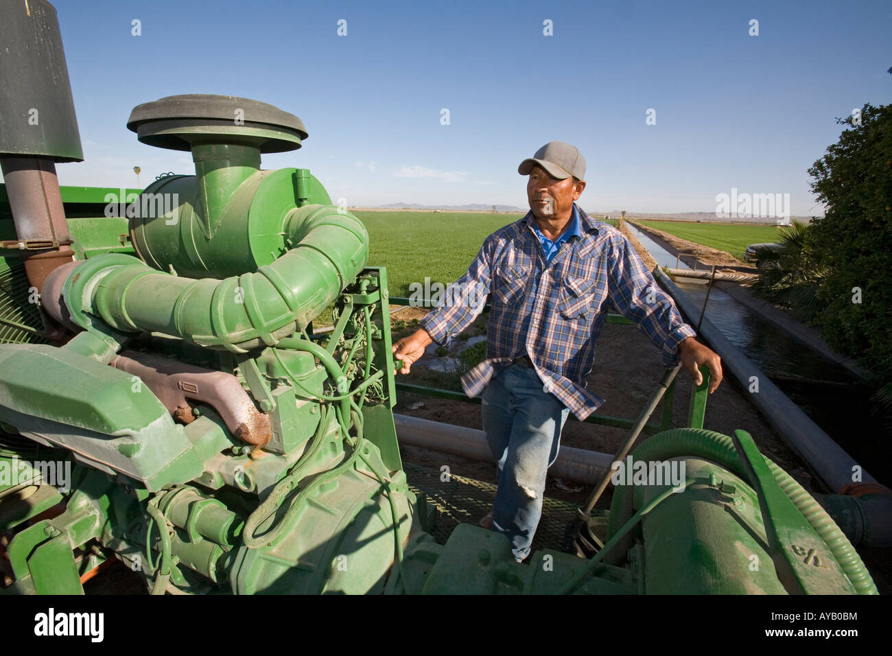 Yuma Arizona A Hispanic Arbeiter auf einem großen Bauernhof betreibt eine Pumpe, die Wasser auf die Felder für die Bewässerung sendet Stockfoto