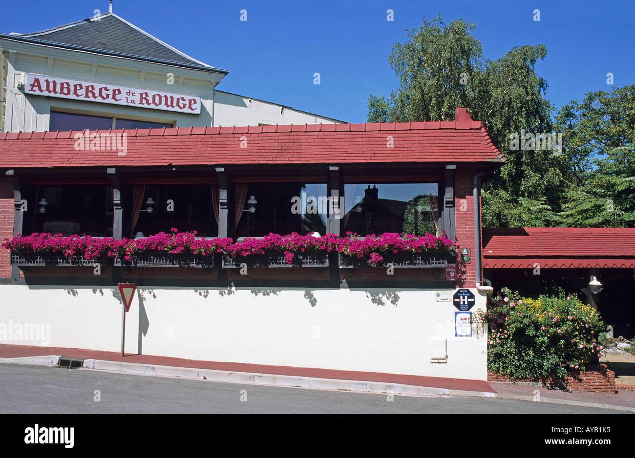 Leuchtend rosa Blüten hängen von den Fenstern des Restaurants Auberge De La Rouge in Fecamp Stockfoto