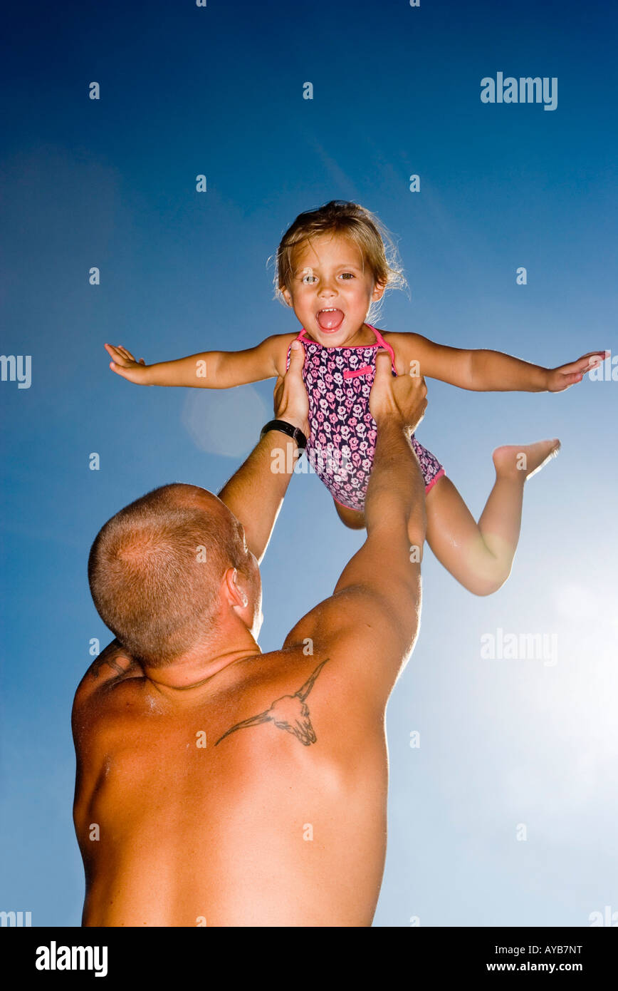 Junger Vater Holding Tochter oben in der Luft Stockfoto