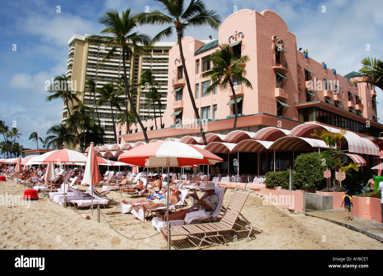 Sonnenanbeter am Strand von Waikiki, außerhalb der legendären Royal Hawaiian Hotel auch bekannt als Pink Palace des Pazifiks Stockfoto