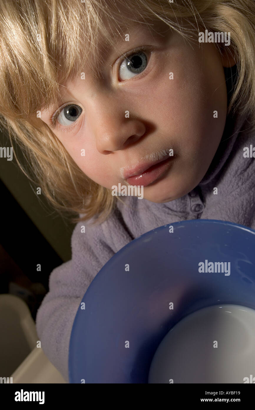 Mädchen trinken Milch ernst zeigt den Inhalt ihres Glases Stockfoto