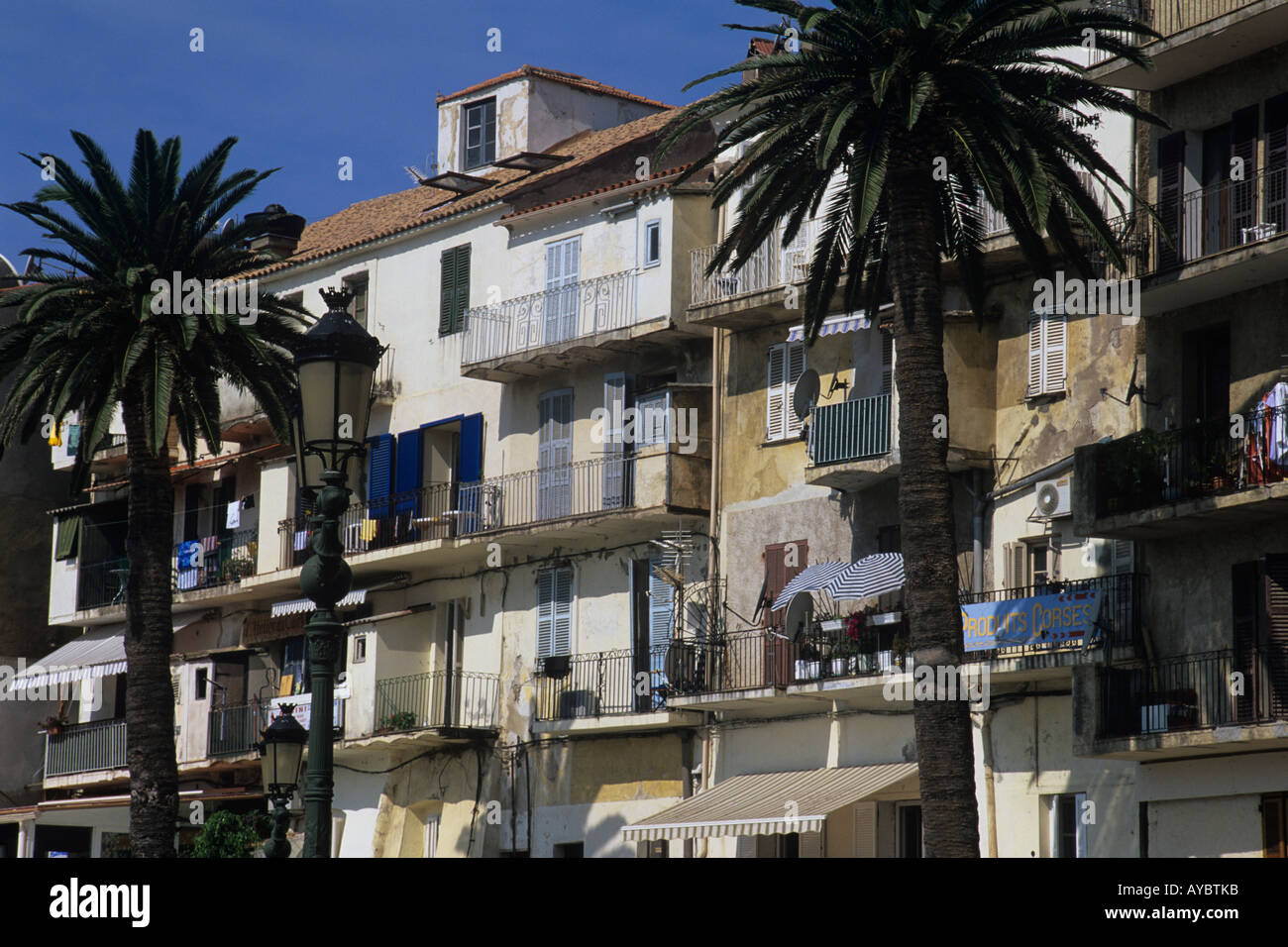 Balkone und Fensterläden. Farbenfrohe Gebäude direkt am Wasser im Hafen von Calvi, Corsica. Stockfoto