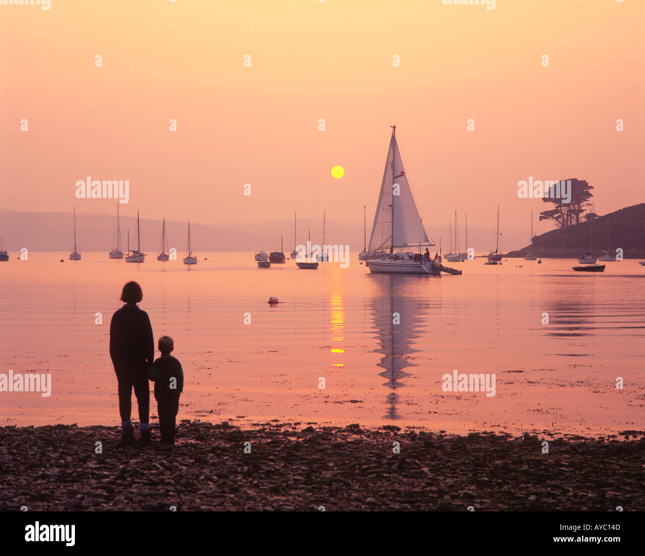 Mutter & Sohn Silhouette bei Sonnenuntergang beobachten Yacht übergeben Messack Point St nur In Roseland Carrick Straßen Cornwall England UK Stockfoto