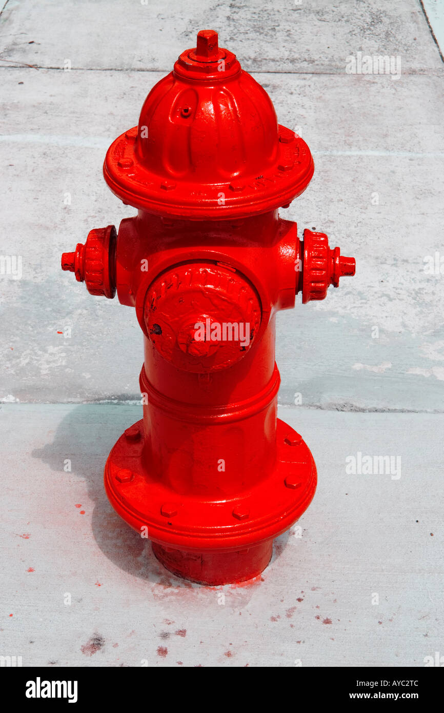 ein hellen roten Hydranten ragt aus dem Bürgersteig Stockfoto
