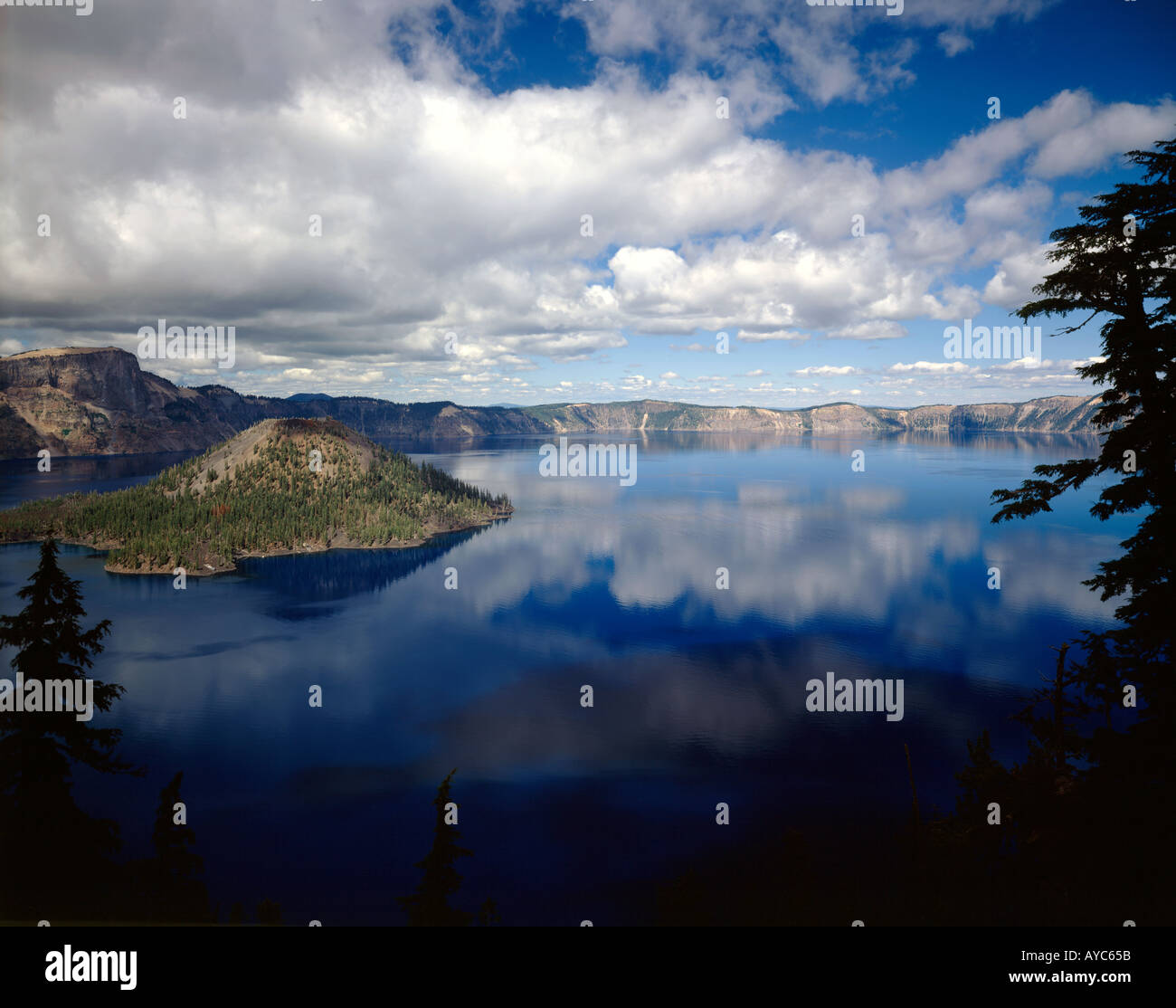 Crater Lake Nationalpark in Oregon mit Wizard Island und dem ruhigen Seewasser reflektiert die Wolke gefüllt Himmel Stockfoto