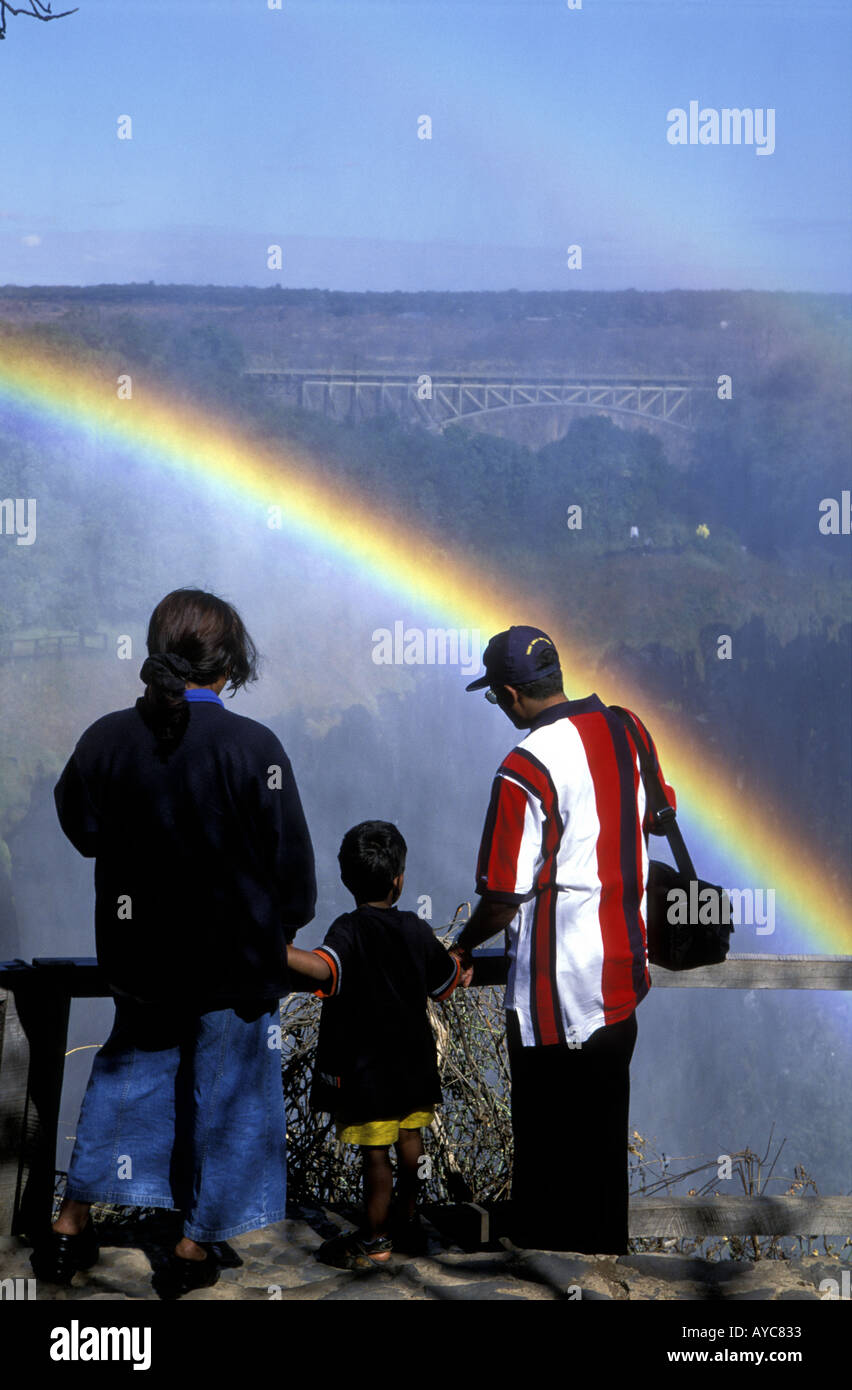 Eine Familie viel Freude beim Betrachten des doppelten Regenbogens in der Gischt der Victoriafälle aus Sambia Seite Afrika Stockfoto