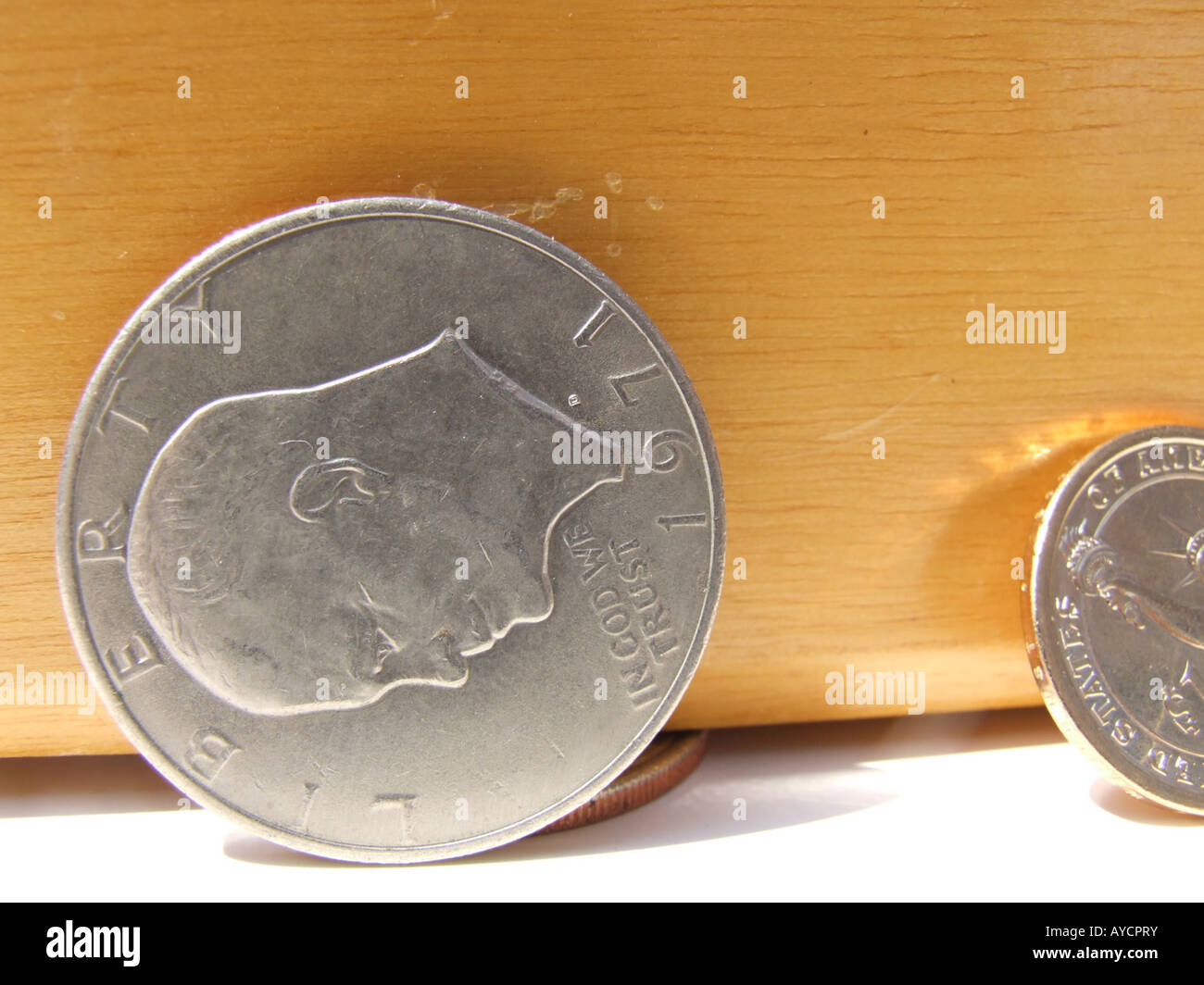 Vorderseite einer Eisenhower-Dollar-Münze eine Holzkiste mit ein Blick auf eine neuere farbige Dollar Goldmünze gelehnt... Stockfoto