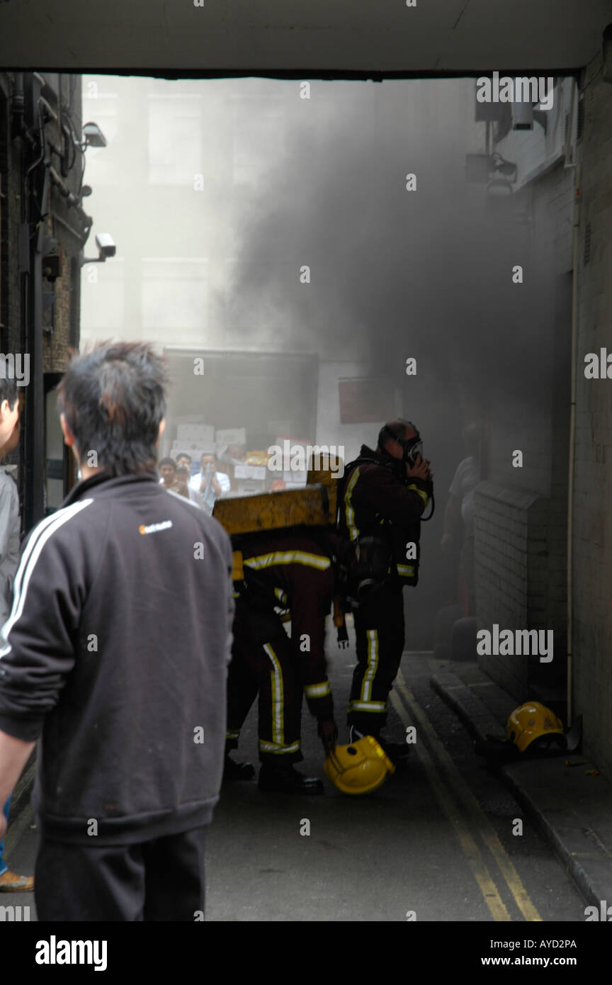 Zwei Feuer-Offiziere mit Masken in eine brennende Restaurant in Londons Chinatown mit Mitarbeitern auf ein Stockfoto