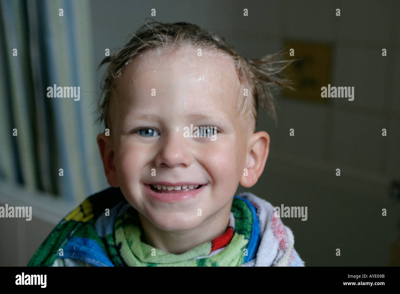 Vier Jahre alte junge lächelt in die Kamera, nachdem er seine Haare gekämmt für Läuse von seiner Mutter Stockfoto
