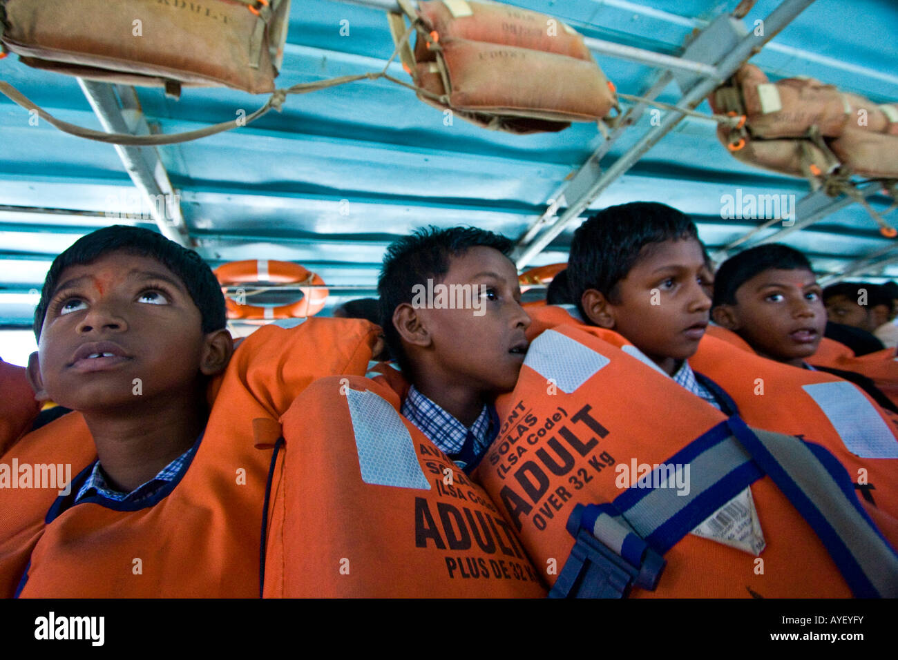 Indische jungen tragen Orange Rettungsringe auf der Fähre nach Swami Vivekananda Rock Memorial in Kanyakumari Südindien Stockfoto