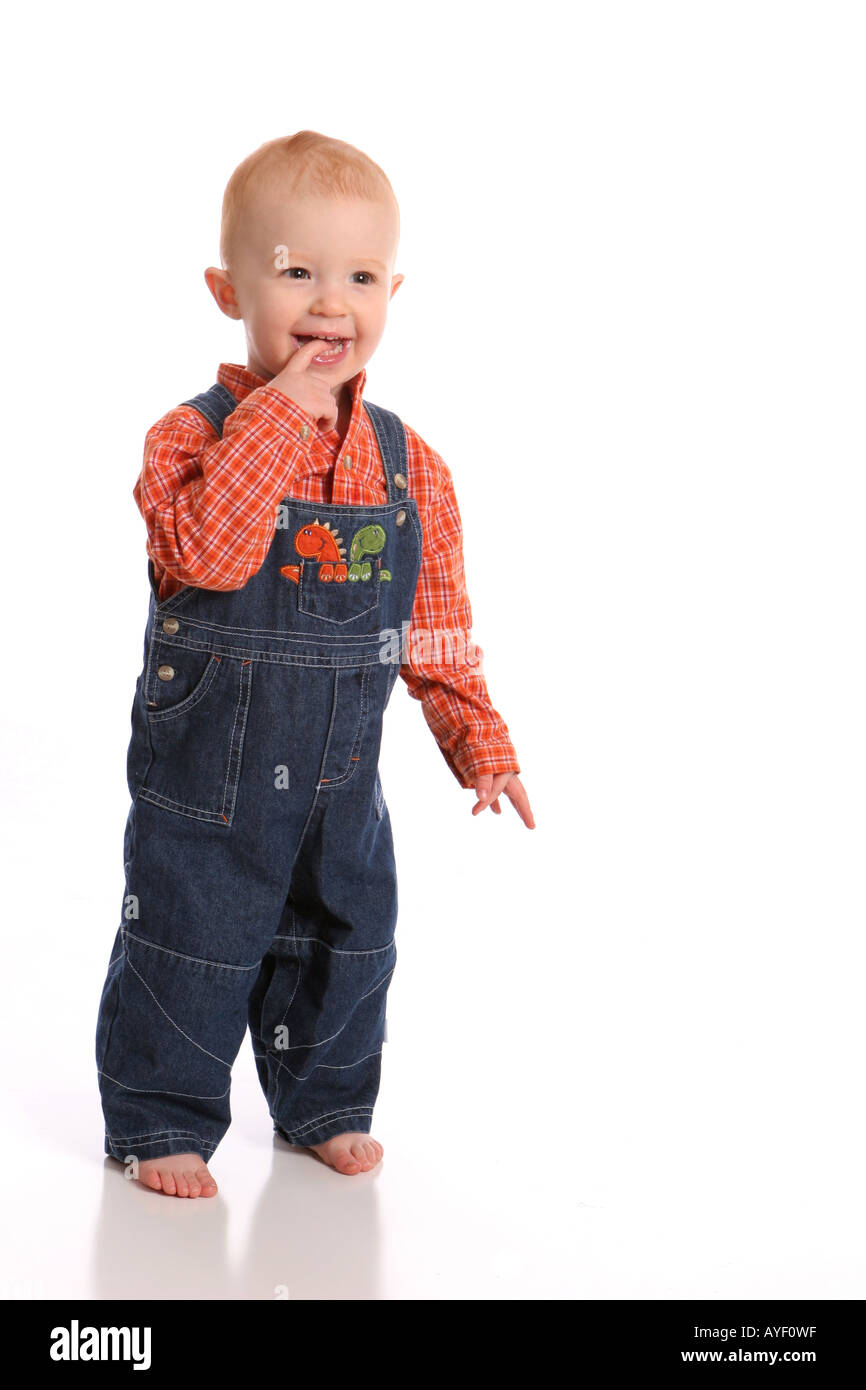 Kleinkind in Overalls stehen Stockfoto