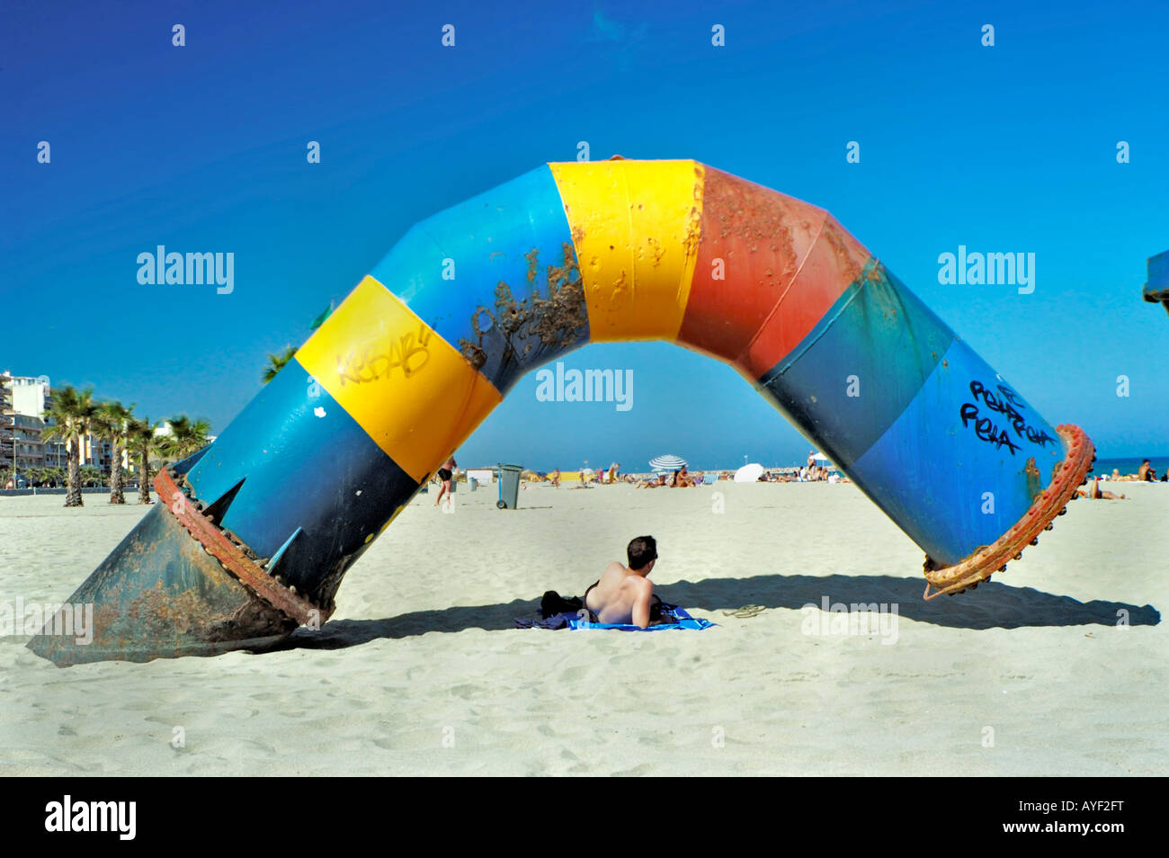 Perpignan Frankreich, Strand-Szene mit Mann entspannen unter Strand Drain Pipe vor Mittelmeer Stockfoto