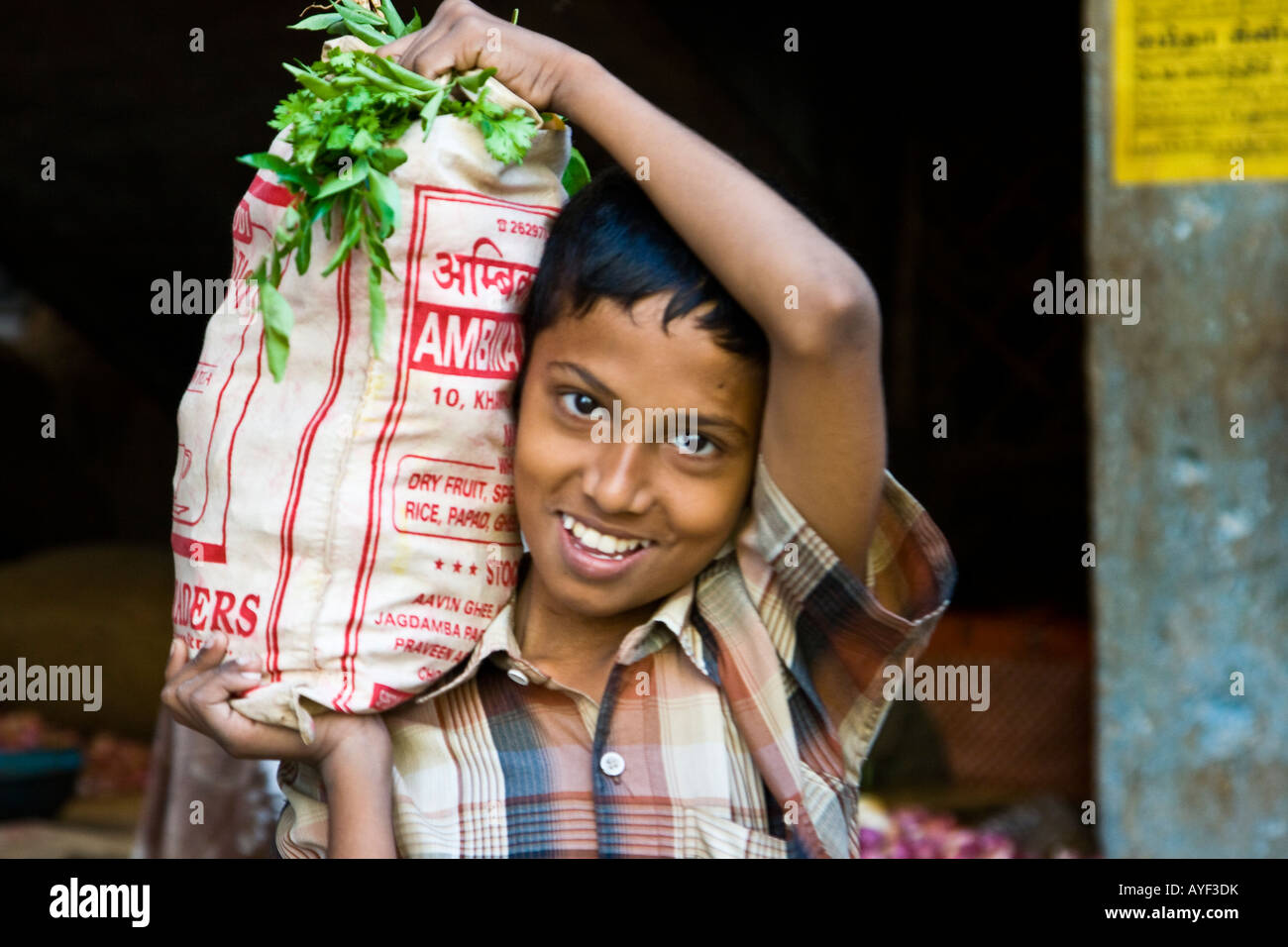 Lächelnde junge mit einer Tasche von Gemüse in einem Gemüsemarkt in Madurai Südindien Stockfoto