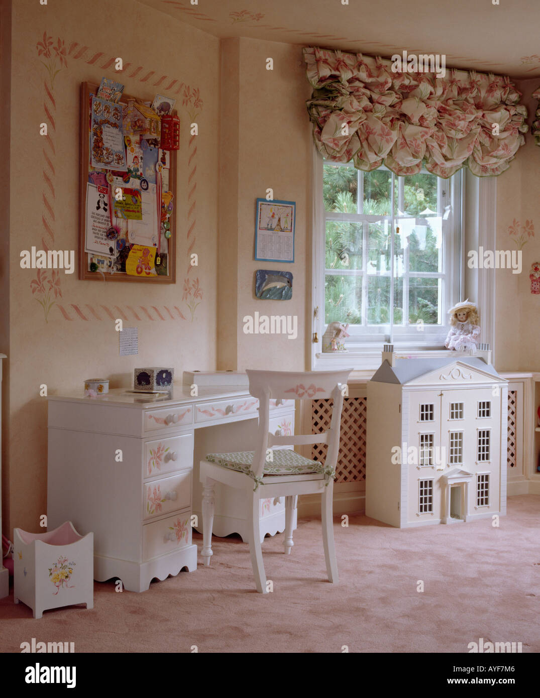 Pfirsich Schlafzimmer mit Dollshouses unter Fenster mit Schwalbenschwanz blind und Stadtansichten Wände Stockfoto