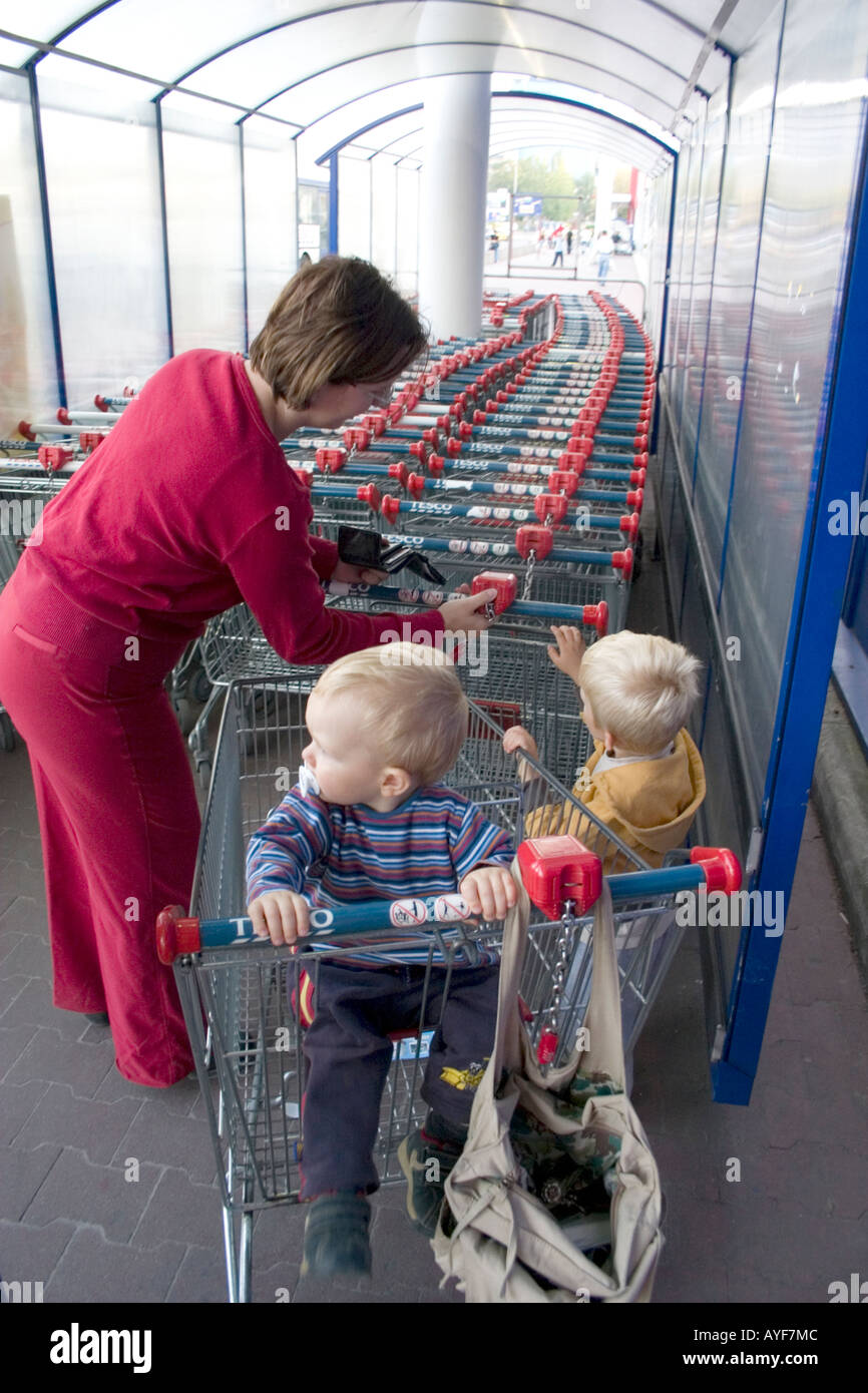 Polnische Mutter Platzierung Münze in den Schlitz zu entsperren  Einkaufswagen im Supermarkt Tesco. Lodz Polen Stockfotografie - Alamy