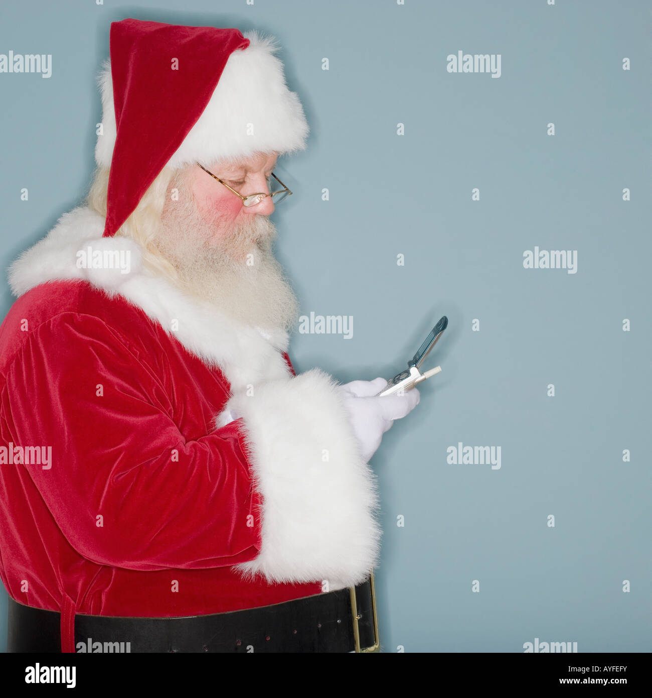 Santa Claus Blick auf Handy Stockfoto