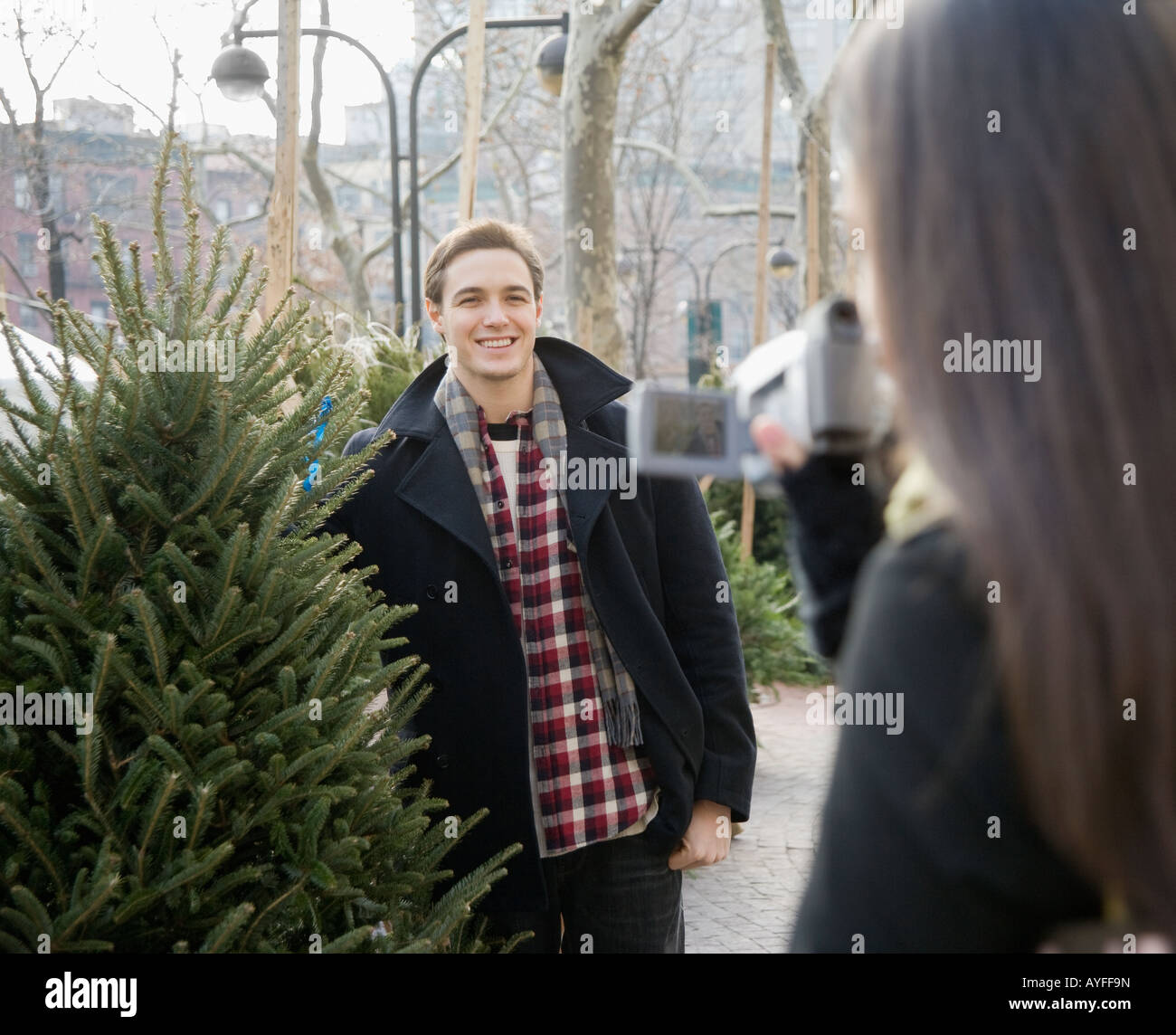 Frau-video-Aufnahme-Freund mit Weihnachtsbaum Stockfoto