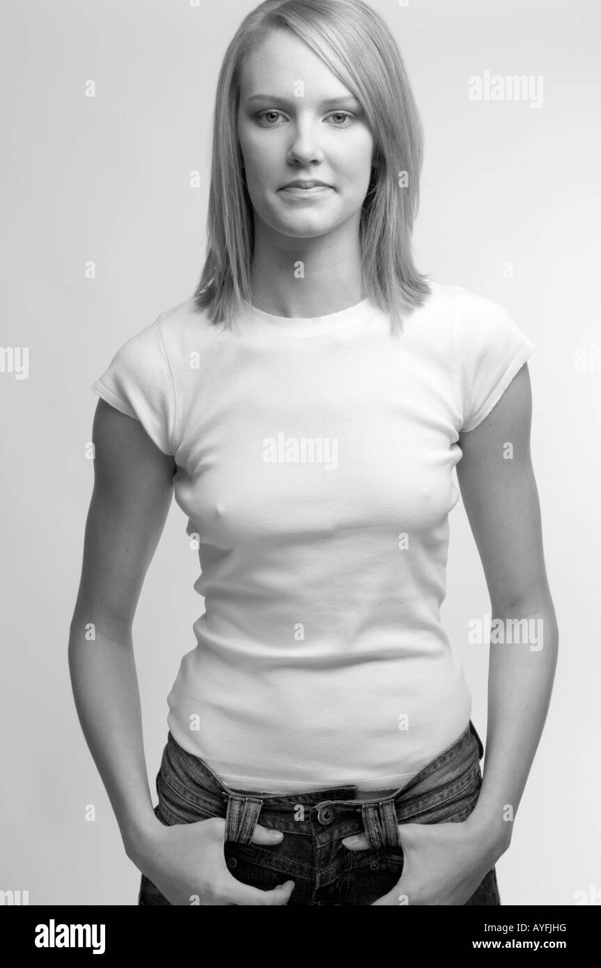 Junge blonde behaarte Frau trägt weiße T-shirt und Blue Jeans Blick direkt in die Kamera im Fotostudio Stockfoto