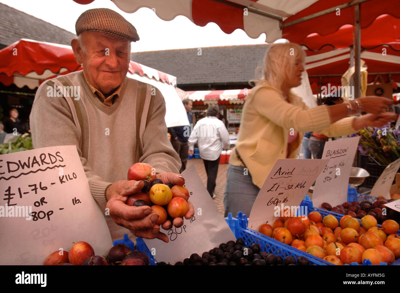 EIN STANDBESITZER ZEIGT SEINE FRISCHE PRODUKTE AUF DEM BAUERNMARKT IN STROUD GLOUCESTERSHIRE UK Stockfoto