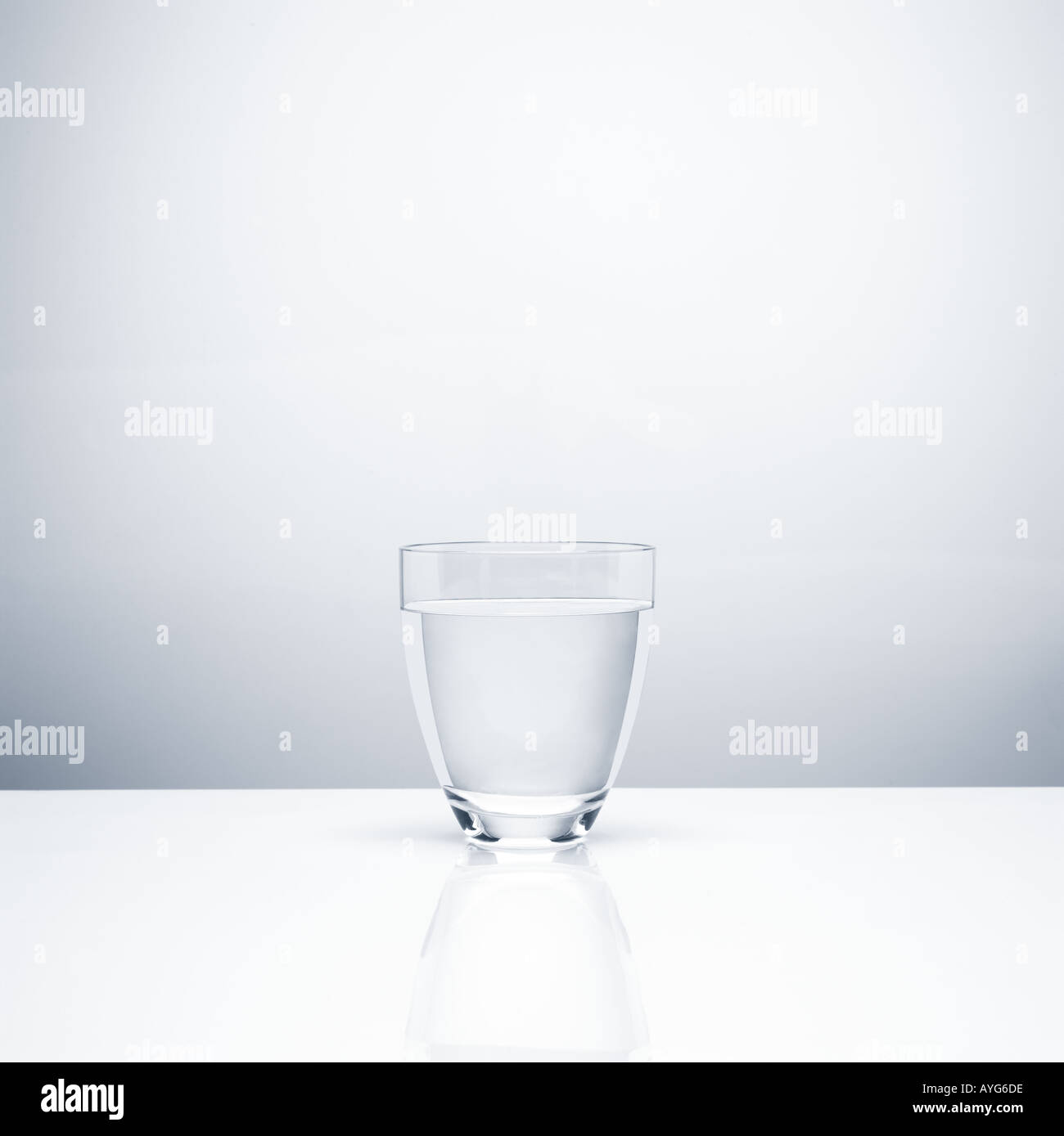 Ein Glas mit klarem Wasser auf neutralem Hintergrund Stockfoto