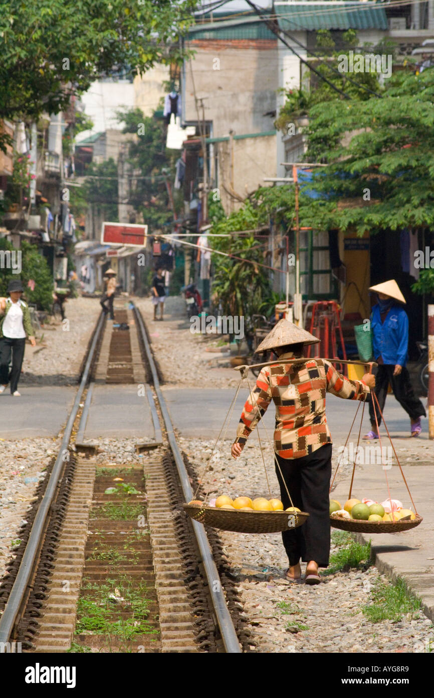 Frau einen vietnamesischen Stil Hut zu einem städtischen Bahnübergang Hanoi Vietnam Stockfoto