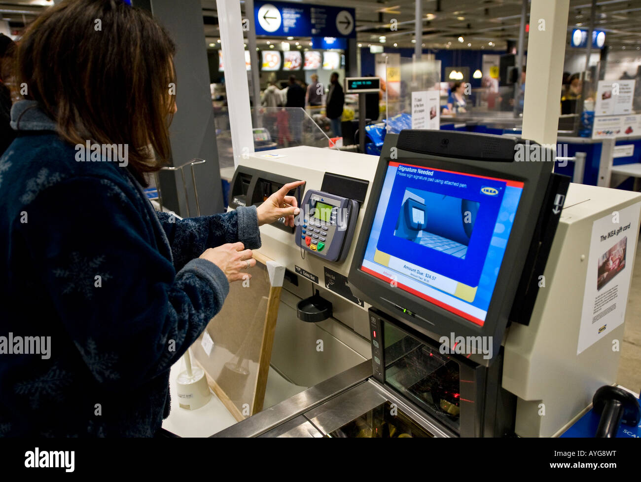 Frau Felder an einer Self-Checkout-Station einer Filiale zu kaufen Stockfoto